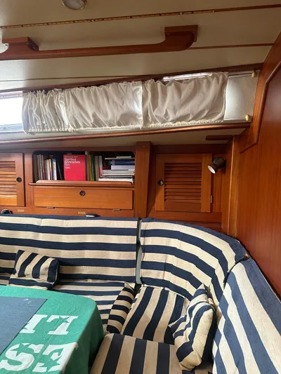 Challenger Yacht Photos Pics Interior of 1992 Hallberg-Rassy 45 yacht with striped seating and wooden cabinetry.