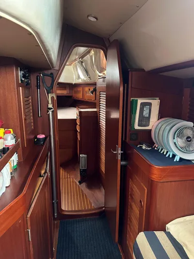 Challenger Yacht Photos Pics Interior of a 1992 Hallberg-Rassy 45 yacht, featuring wooden cabinetry and nautical decor.