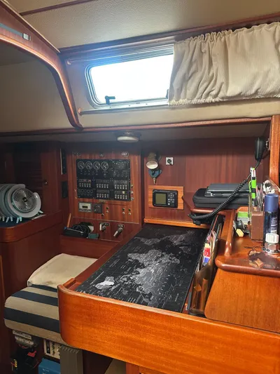 Challenger Yacht Photos Pics Interior of a 1992 Hallberg-Rassy 45 sailboat, featuring a navigation station with wooden cabinetry.