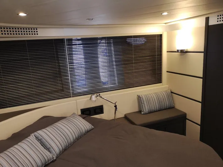  Yacht Photos Pics Luxurious bedroom interior of 2007 Pershing 62 yacht with modern decor and striped pillows.