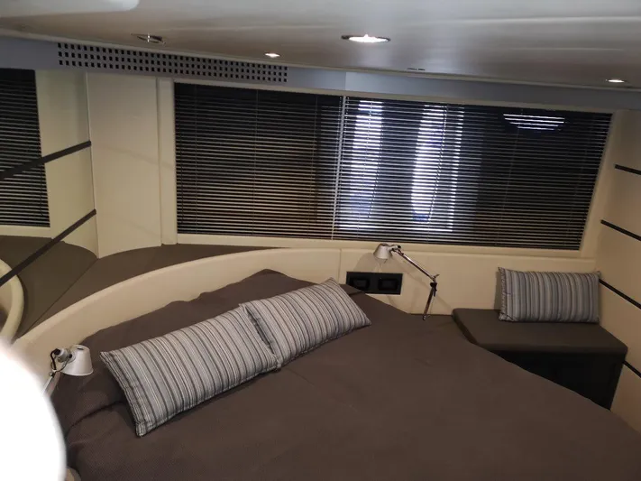  Yacht Photos Pics Luxurious bedroom interior of 2007 Pershing 62 yacht with modern design and striped pillows.