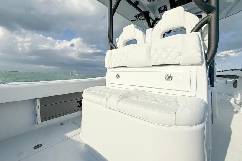  Yacht Photos Pics 2026 Yellowfin 34 Offshore boat interior with white seating, ocean view, and cloudy sky.