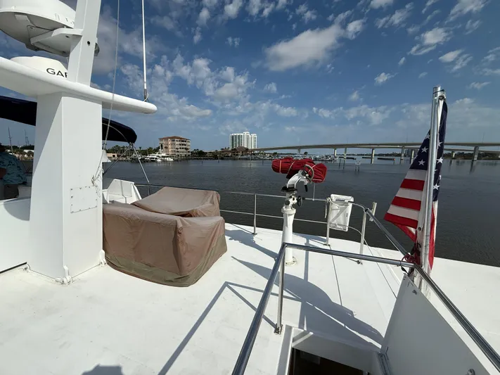  Yacht Photos Pics Pluckebaum Custom 2000 yacht deck with American flag, overlooking calm waters and bridge under blue sky.