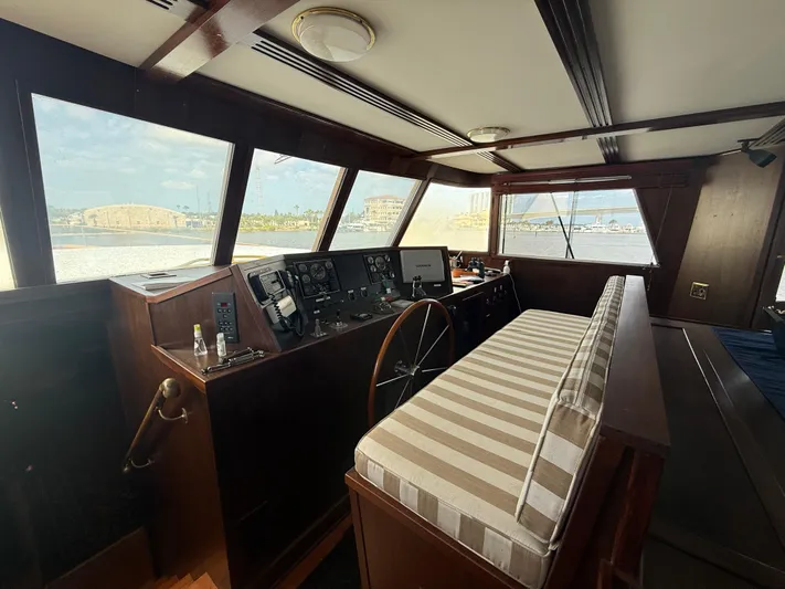  Yacht Photos Pics Pilothouse interior of 2000 Pluckebaum Custom boat with striped seating and navigation controls.