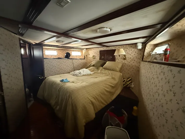  Yacht Photos Pics Cozy bedroom interior of 2000 Pluckebaum Custom boat with floral wallpaper and soft lighting.
