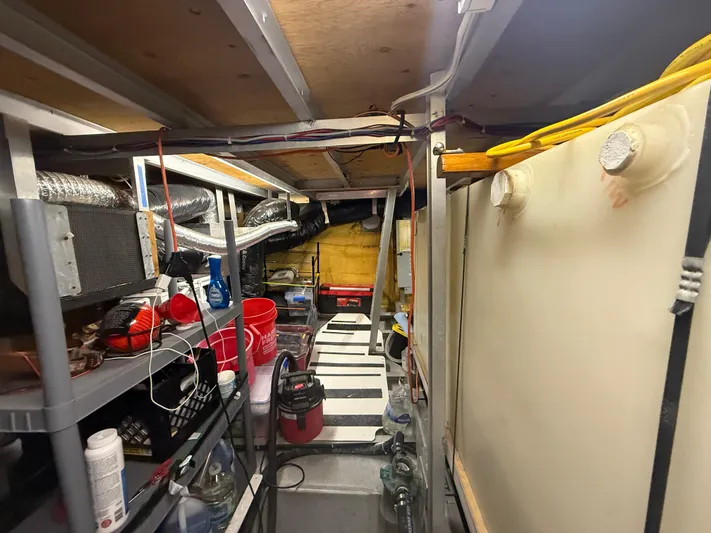  Yacht Photos Pics Engine room of a 2000 Pluckebaum Custom boat with equipment and storage.