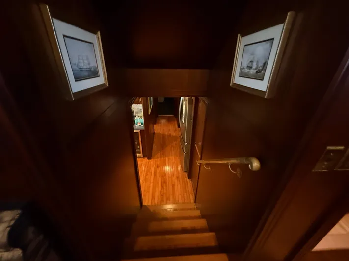  Yacht Photos Pics Stairway inside 2000 Pluckebaum Custom boat, featuring wooden steps and framed nautical art.