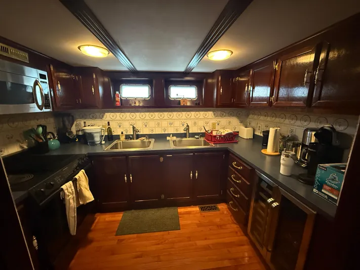  Yacht Photos Pics Kitchen interior of a 2000 Pluckebaum Custom boat with wooden cabinets and modern appliances.