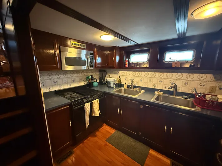  Yacht Photos Pics Cozy kitchen in a 2000 Pluckebaum Custom boat with wood cabinets and modern appliances.
