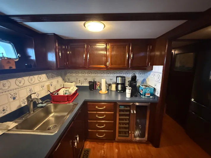  Yacht Photos Pics Kitchen interior of a 2000 Pluckebaum Custom boat with wooden cabinets and modern appliances.