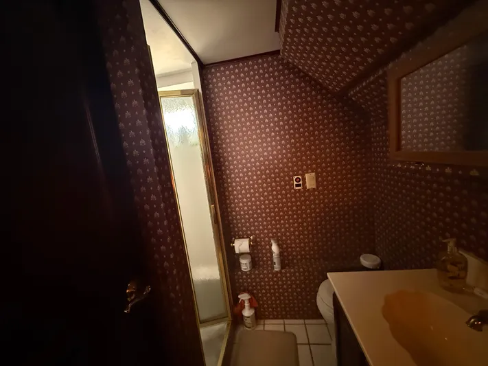  Yacht Photos Pics Small bathroom with patterned wallpaper, shower, and sink in a 2000 Pluckebaum Custom boat.