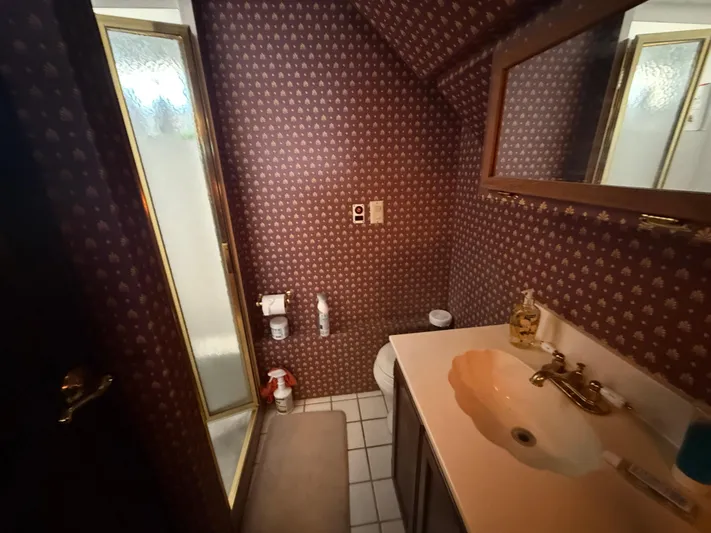  Yacht Photos Pics Small bathroom with patterned wallpaper, shower, and vanity in a 2000 Pluckebaum Custom model.