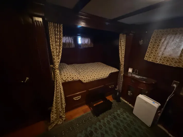  Yacht Photos Pics Cozy cabin interior of 2000 Pluckebaum Custom boat with bed and patterned curtains.