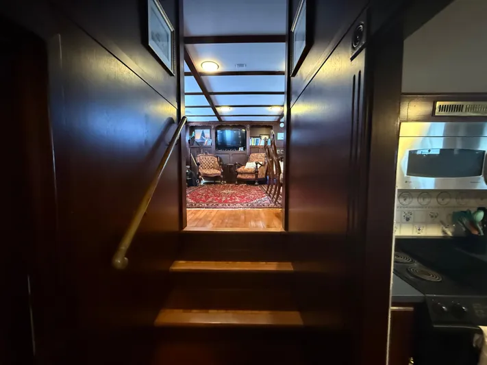  Yacht Photos Pics Interior view of 2000 Pluckebaum Custom yacht, featuring wooden stairs and cozy living area.