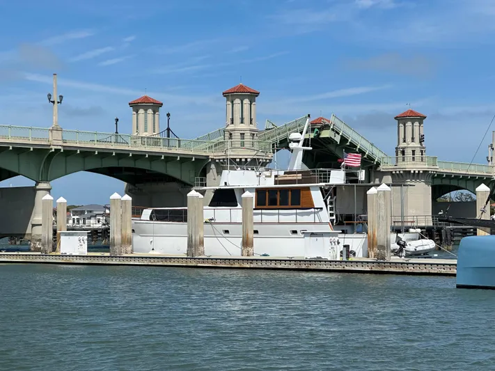  Yacht Photos Pics A 2000 Pluckebaum Custom yacht docked near a historic bridge on a sunny day.