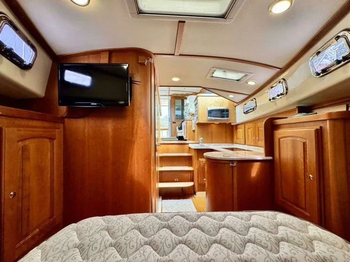 Linda Lou Yacht Photos Pics Interior of a 2018 Legacy 36 yacht with wooden furnishings and TV.