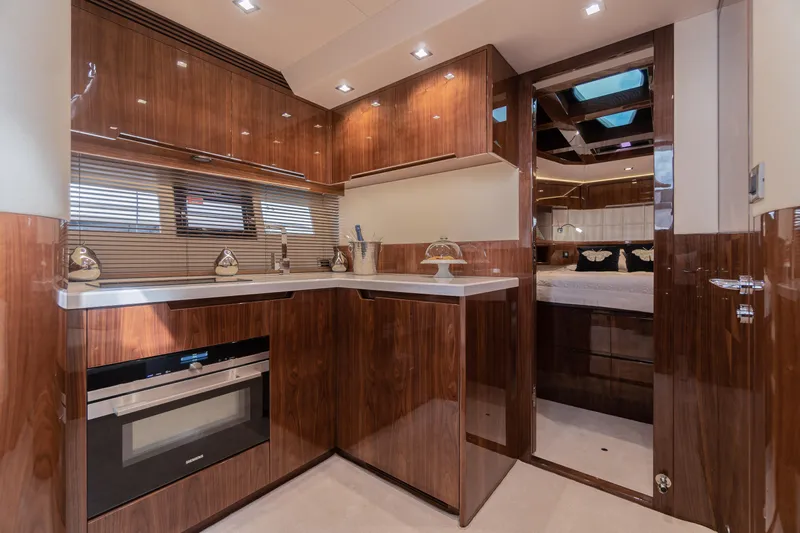 Lady C Yacht Photos Pics Luxurious kitchen interior of 2022 Galeon 485 HTS yacht with wood finish and modern appliances.