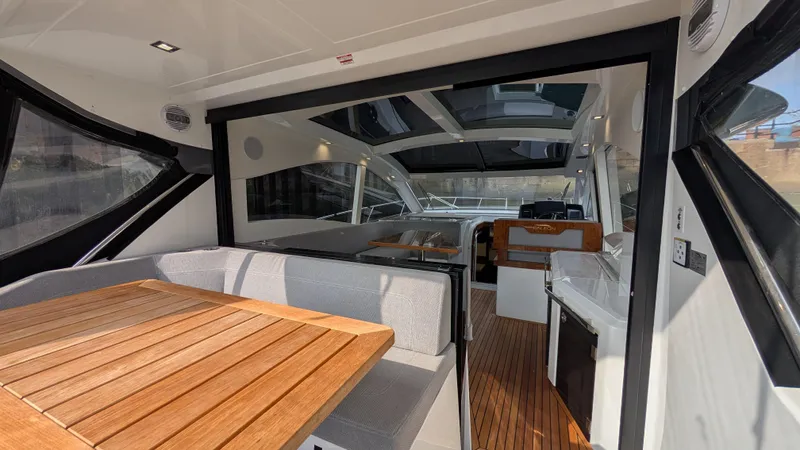 Lady C Yacht Photos Pics 2022 Galeon 485 HTS yacht interior with modern seating and wooden table.