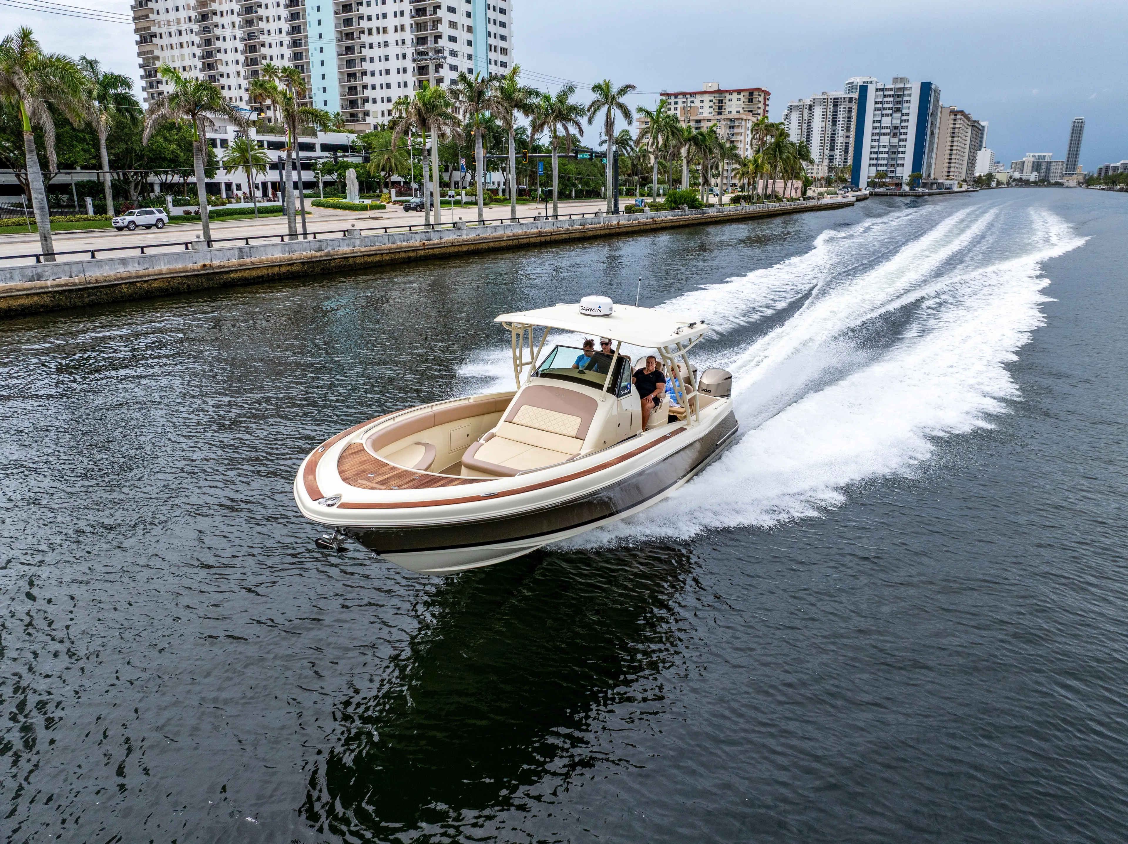 Lady Liberty Yacht Photos Pics 2018 Chris-Craft Catalina 34 cruising on a city waterway with modern buildings in the background.