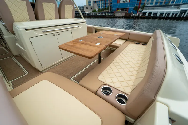 Lady Liberty Yacht Photos Pics 2018 Chris-Craft Catalina 34 interior with elegant seating and wooden table by the water.