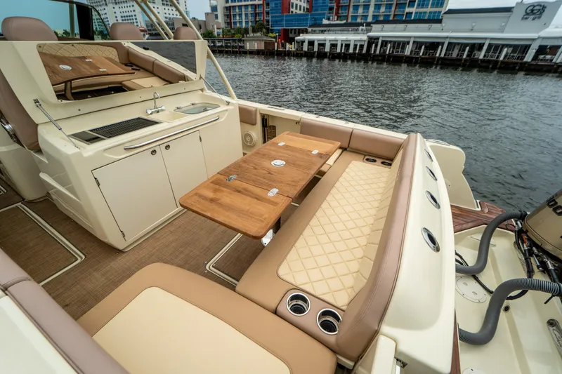 Lady Liberty Yacht Photos Pics 2018 Chris-Craft Catalina 34 interior with seating, table, and kitchenette by the water.