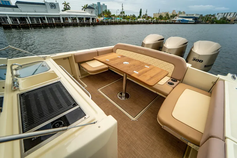 Lady Liberty Yacht Photos Pics 2018 Chris-Craft Catalina 34 boat interior with seating, table, and outboard motors on a waterfront.