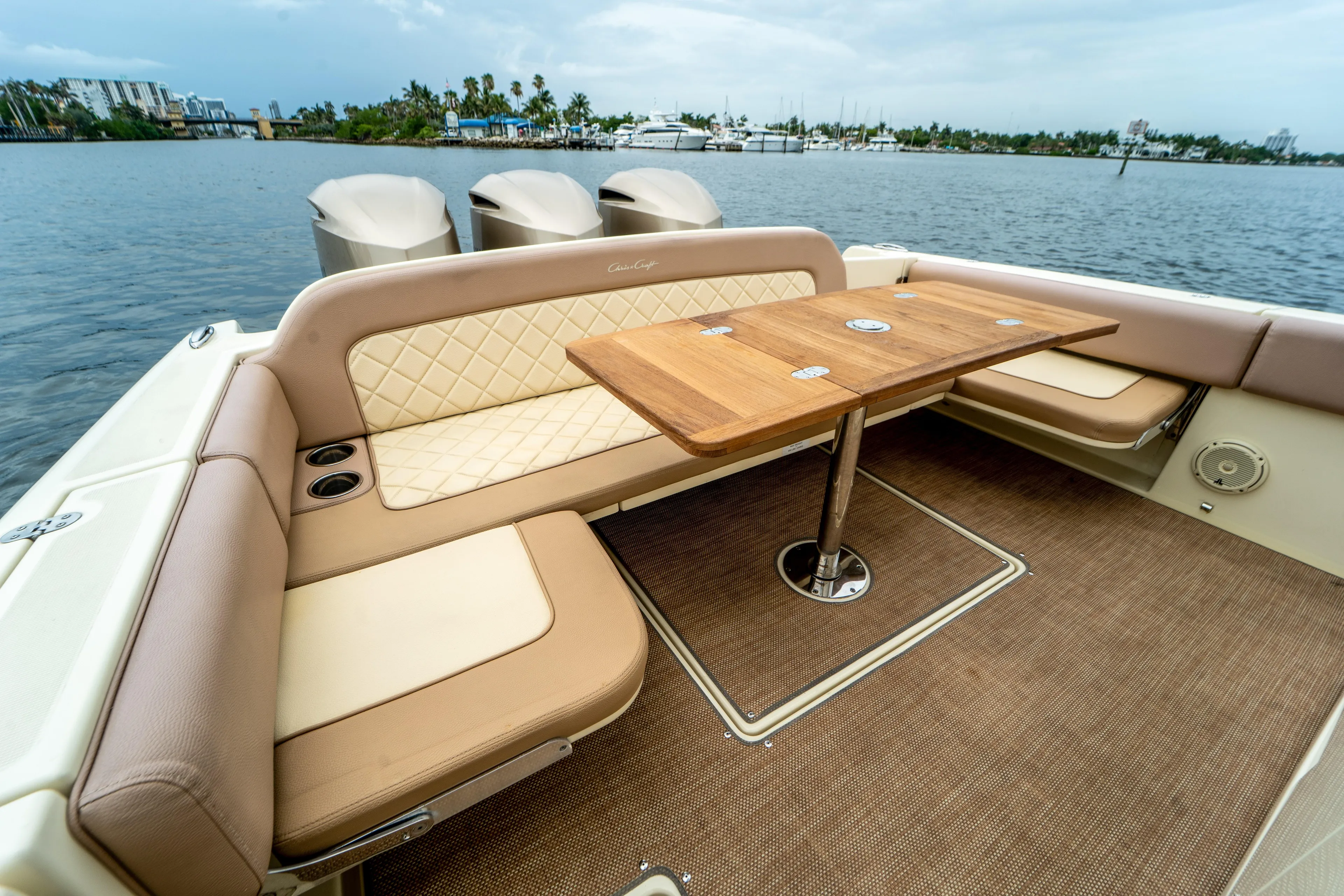 Lady Liberty Yacht Photos Pics 2018 Chris-Craft Catalina 34 boat interior with elegant seating and wooden table on a calm water backdrop.