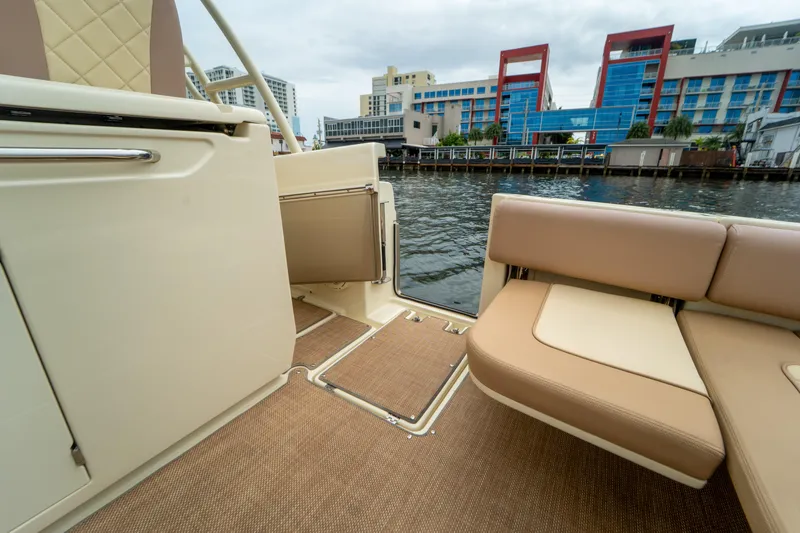 Lady Liberty Yacht Photos Pics 2018 Chris-Craft Catalina 34 interior with beige seating, dockside view, modern buildings in background.