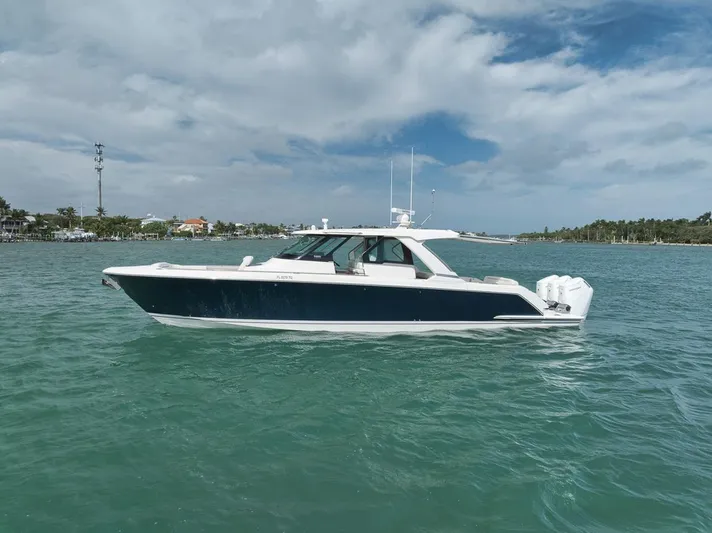 Sea Ya Yacht Photos Pics 2022 Tiara Sport 48LS boat on calm water under a partly cloudy sky.
