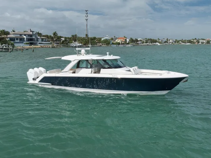 Sea Ya Yacht Photos Pics 2022 Tiara Sport 48LS luxury boat on turquoise water near coastal homes.
