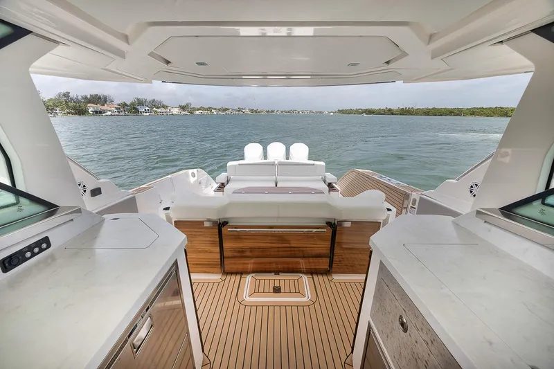 Sea Ya Yacht Photos Pics Interior view of 2022 Tiara Sport 48LS yacht with elegant wood flooring and scenic water backdrop.