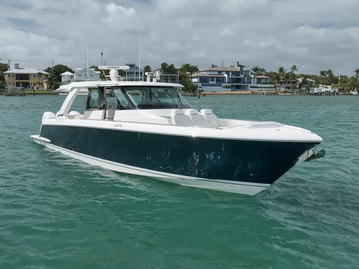 Sea Ya Yacht Photos Pics 2022 Tiara Sport 48LS luxury boat cruising on turquoise water near coastal homes.
