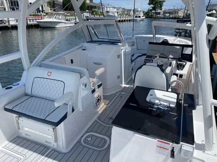  Yacht Photos Pics 2024 Sea Fox 288 Traveler boat interior with seating and control console, docked by waterfront homes.