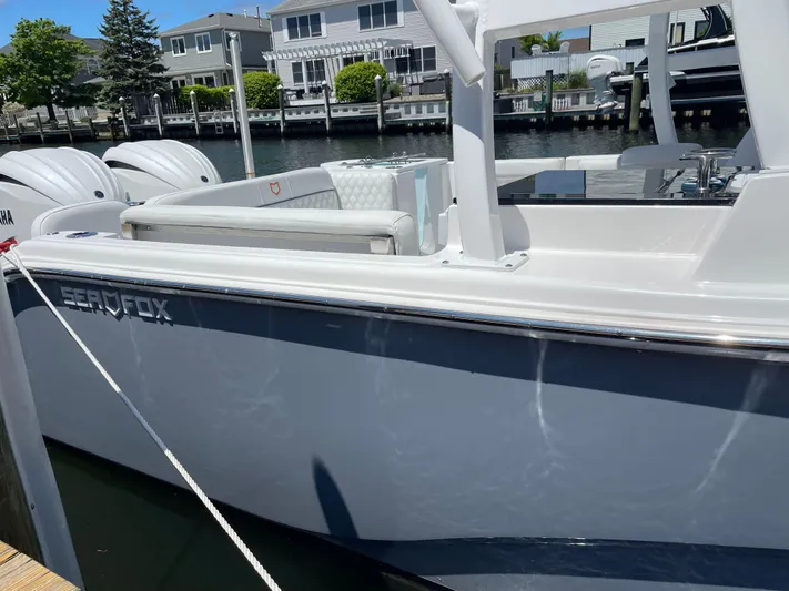  Yacht Photos Pics 2024 Sea Fox 288 Traveler boat docked, showcasing sleek design and dual outboard engines.