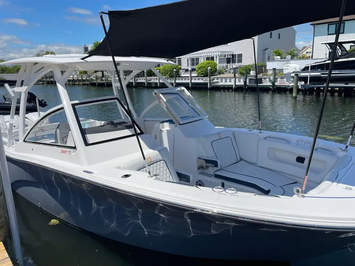  Yacht Photos Pics 2024 Sea Fox 288 Traveler boat docked with sunshade, white and blue exterior.