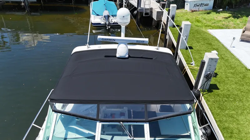 Reel Estate Yacht Photos Pics 1998 Tiara Yachts 3500 Express docked, featuring black canopy and Garmin equipment.