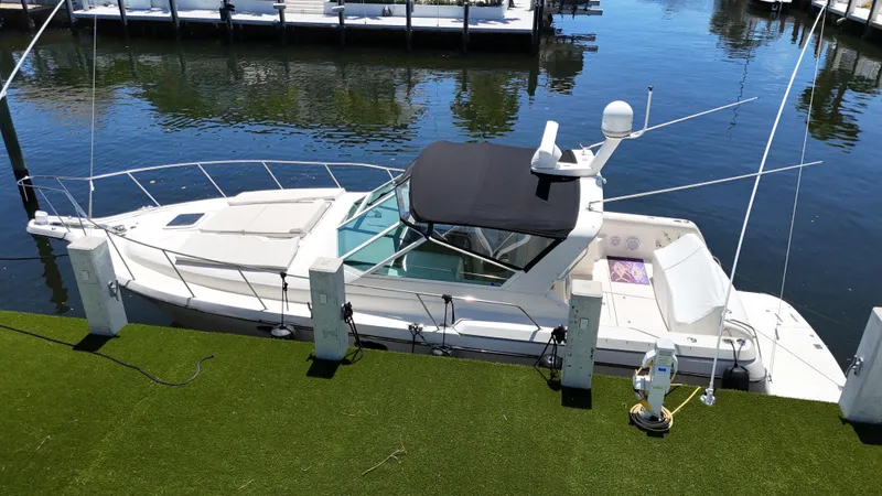 Reel Estate Yacht Photos Pics 1998 Tiara Yachts 3500 Express docked on calm water.