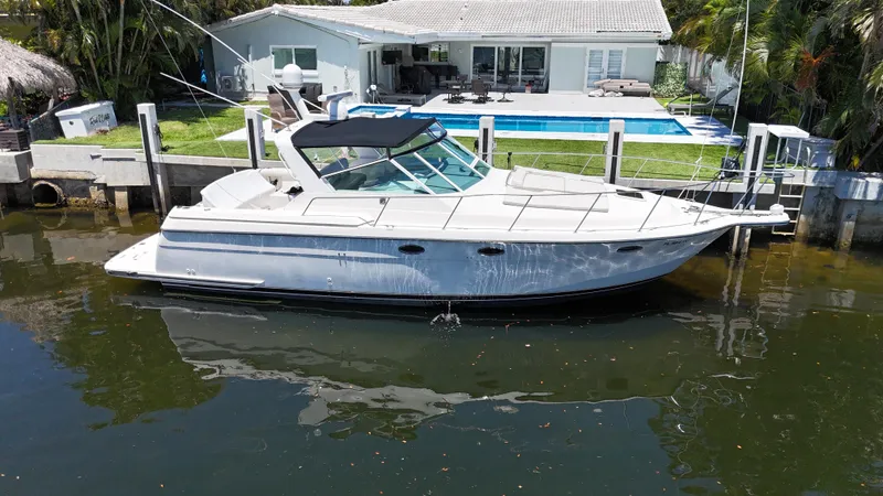Reel Estate Yacht Photos Pics 1998 Tiara Yachts 3500 Express docked by a waterfront home with a pool.