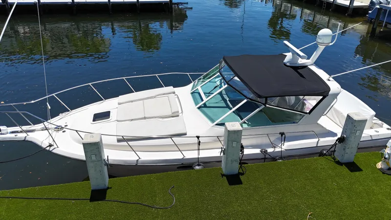 Reel Estate Yacht Photos Pics 1998 Tiara Yachts 3500 Express docked, featuring sleek design and black canopy.