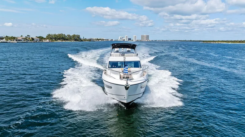 Almost Heaven Yacht Photos Pics 2021 Sunseeker Manhattan 52 yacht cruising on open water under a blue sky.