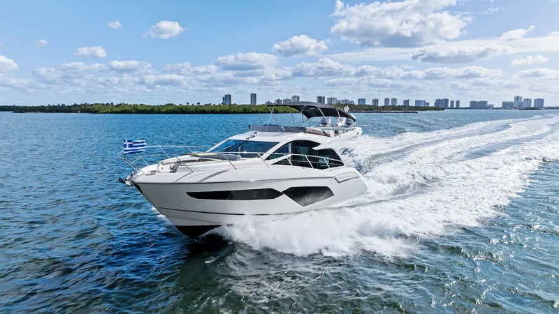 Almost Heaven Yacht Photos Pics 2021 Sunseeker Manhattan 52 yacht cruising on open water under a clear blue sky.