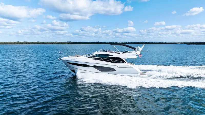 Almost Heaven Yacht Photos Pics 2021 Sunseeker Manhattan 52 yacht cruising on open water under a clear blue sky.