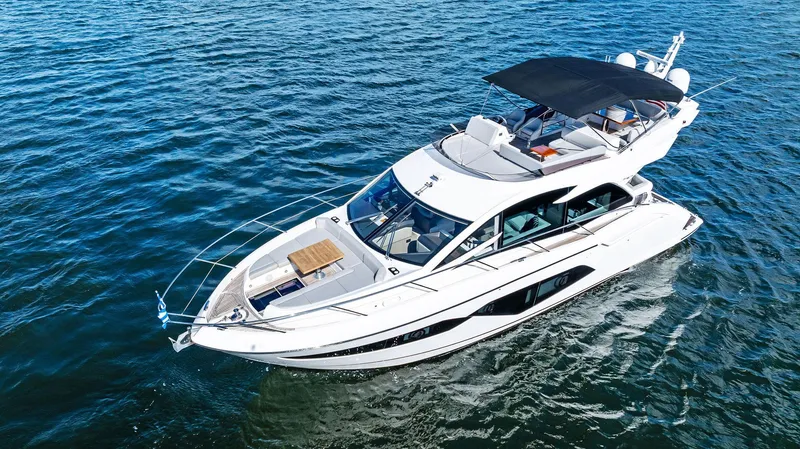 Almost Heaven Yacht Photos Pics 2021 Sunseeker Manhattan 52 yacht cruising on open water, featuring sleek design and spacious deck.