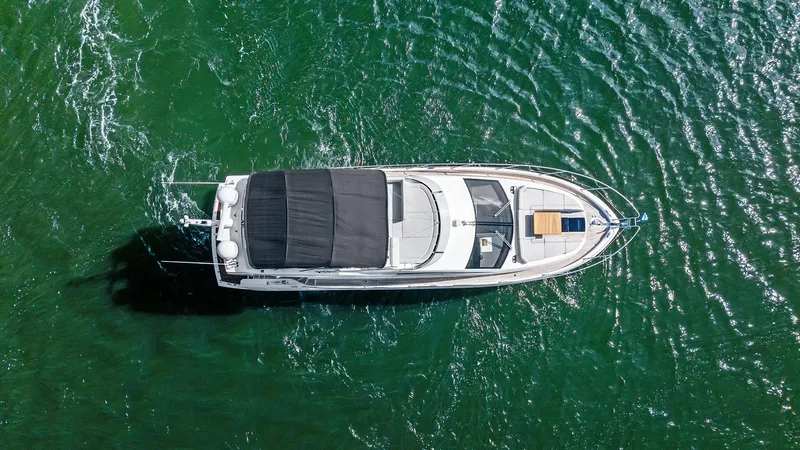 Almost Heaven Yacht Photos Pics Aerial view of 2021 Sunseeker Manhattan 52 yacht on green water.