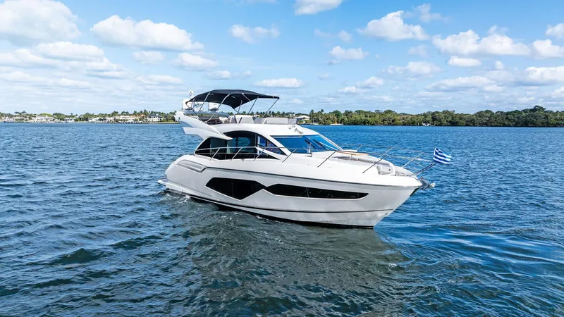 Almost Heaven Yacht Photos Pics 2021 Sunseeker Manhattan 52 yacht cruising on a sunny day, blue sky, calm waters.