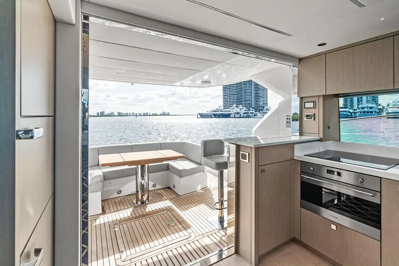 Almost Heaven Yacht Photos Pics Interior view of 2021 Sunseeker Manhattan 52 yacht, featuring modern kitchen and seating area with ocean view.