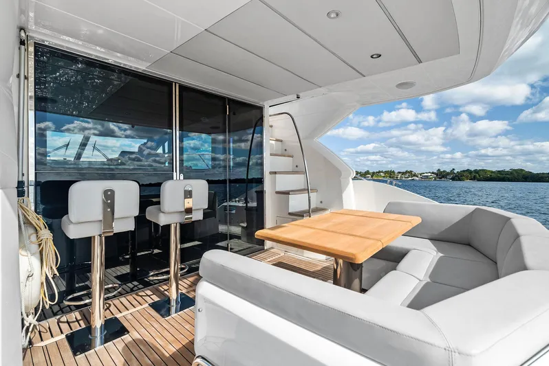 Almost Heaven Yacht Photos Pics Luxurious Sunseeker Manhattan 52 yacht deck with seating, table, and ocean view, 2021 model.