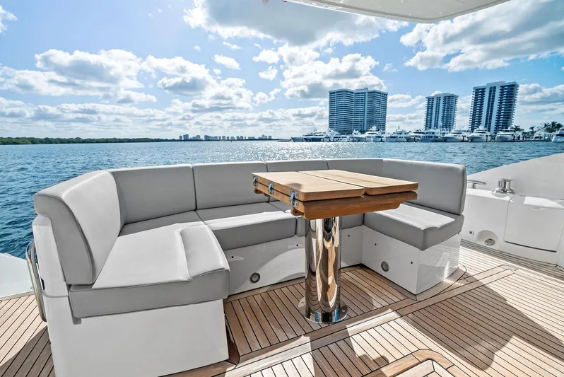 Almost Heaven Yacht Photos Pics Luxurious Sunseeker Manhattan 52 yacht deck with seating, table, and ocean view, 2021 model.