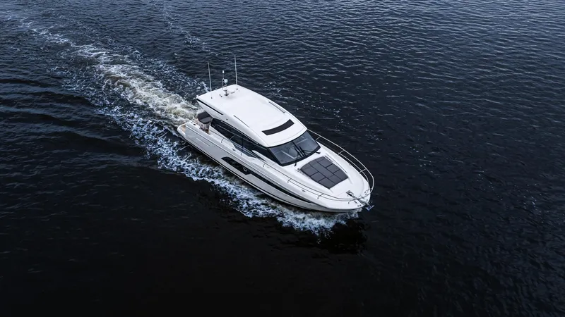 In Stock Yacht Photos Pics 2023 Prestige 520S yacht cruising on open water, aerial view.