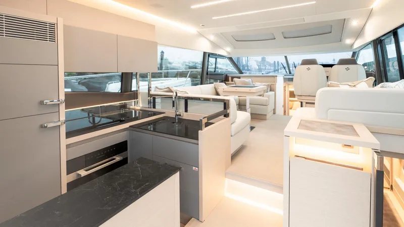 In Stock Yacht Photos Pics Luxurious interior of 2023 Prestige 520S yacht with modern kitchen and seating area.